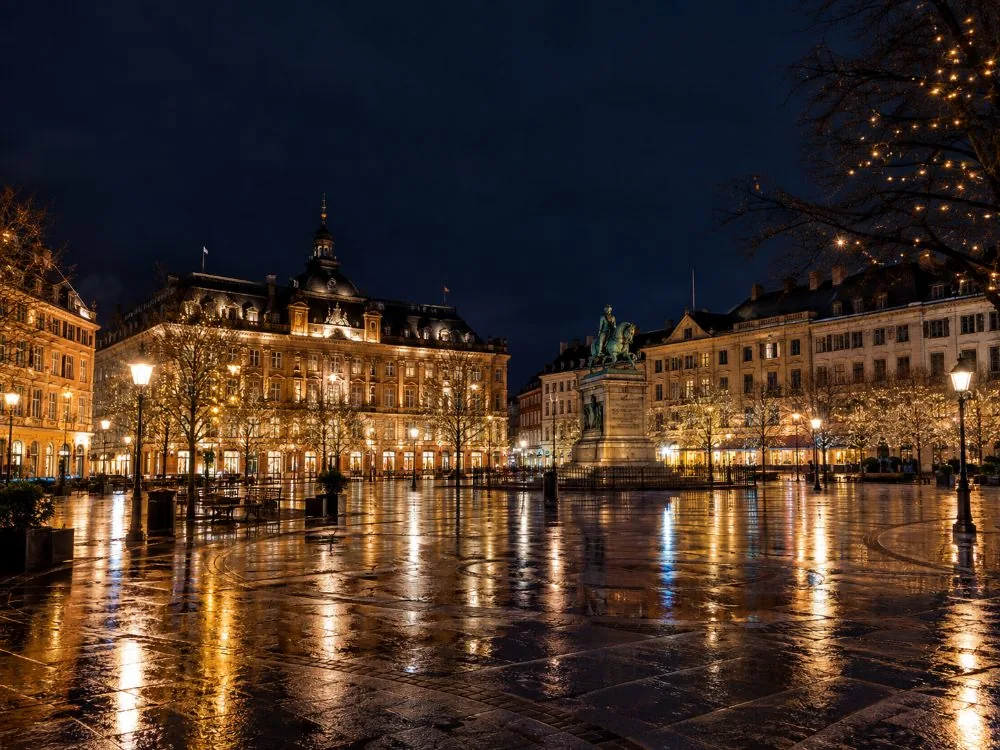 Kongens Nytorv in Copenhagen lit at night, where the ghost walk ends