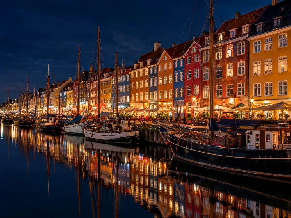 The painted houses along Nyhavn reflected in the canal at night